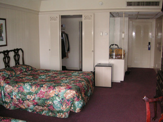 Bed, Mini-Fridge and Entry to the bathroom